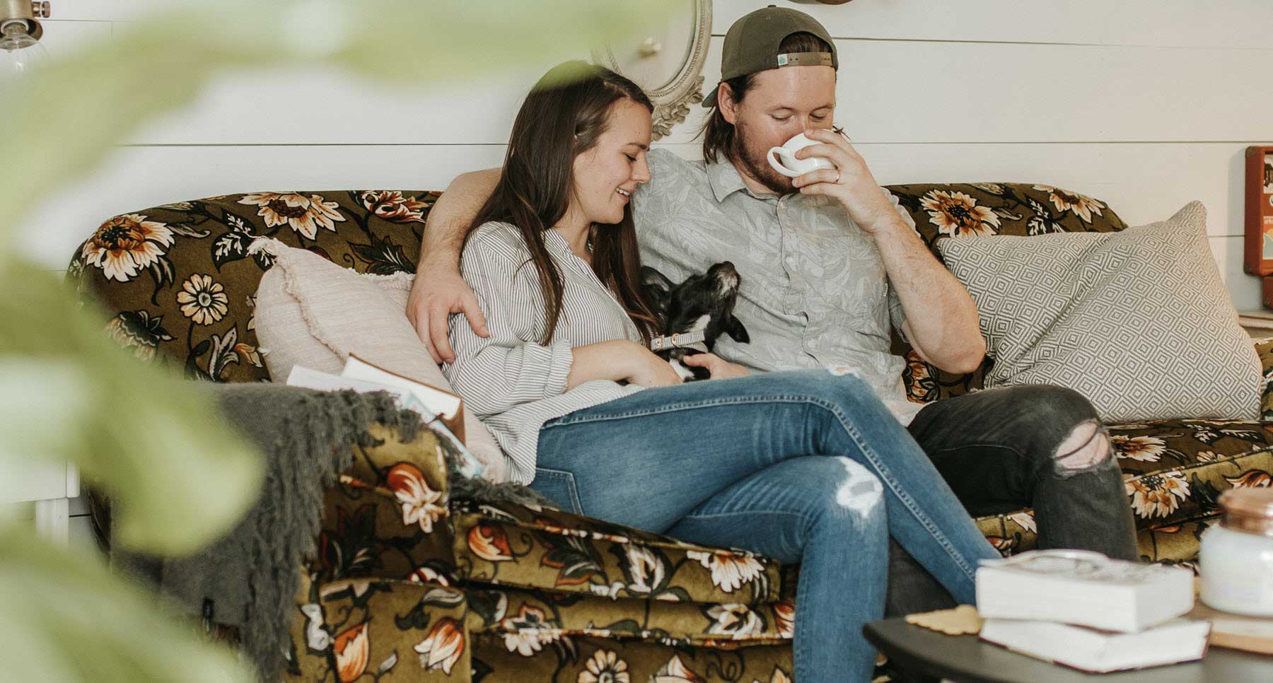 couple-sitting-on-sofa-with-their-dog-enjoying-a-healthy-relationship