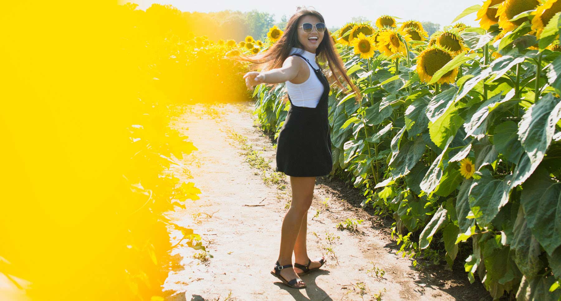 Girl-smiling-in-a-field-of-sunflowers