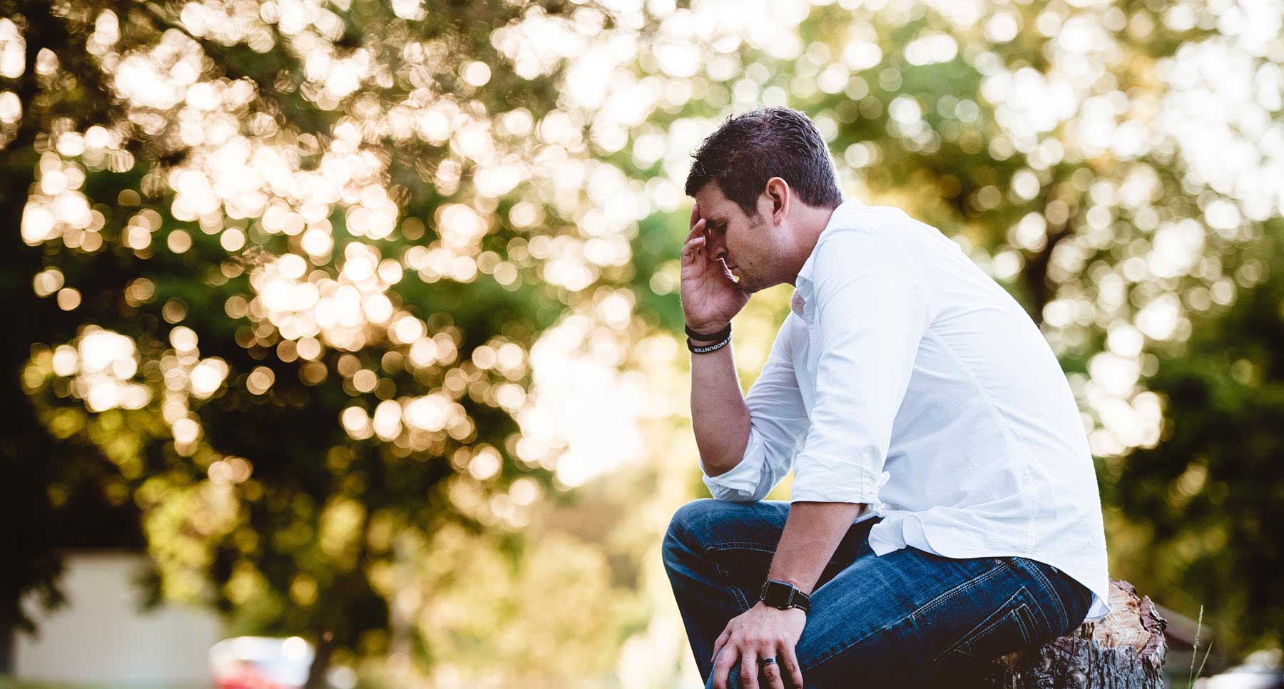 man sitting outside thinking about the guilt he is feeling