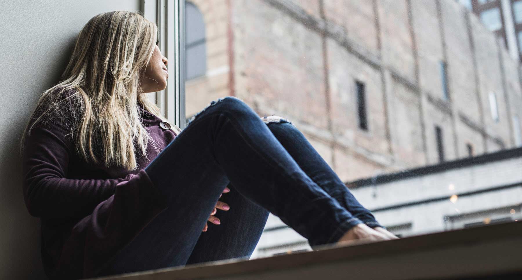 woman looking out the window wondering does God Forgive her