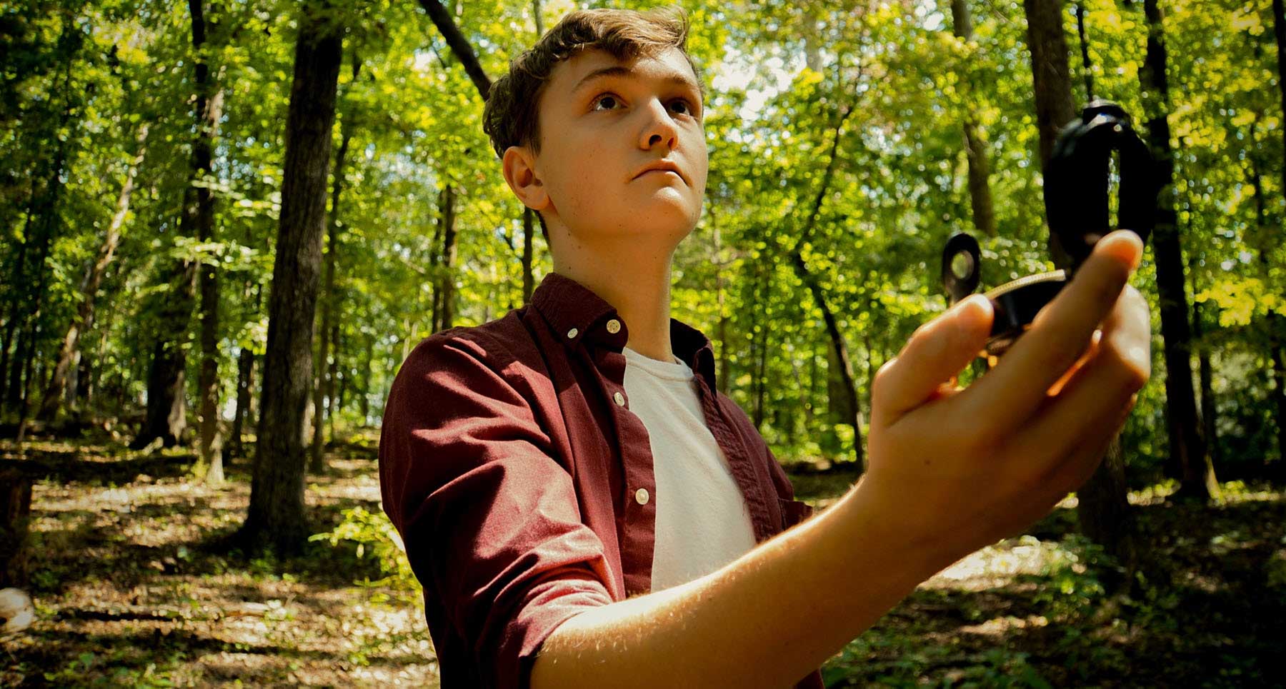 guy-standing-in-the-woods-with-a-compass-wanting-to-make-better-choices-in-life